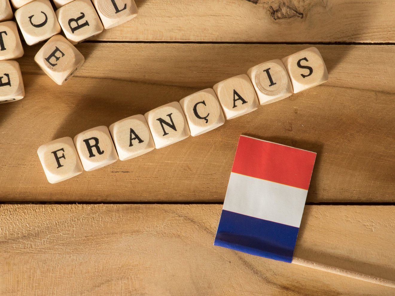 Frankreich Fähnchen und Würfel auf einem Tisch die das Wort FRANCAIS ergeben