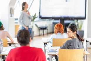 Deutschkurse 3 VHS Dresden Erwachsene unterschiedlicher Herkunft sitzen in einem Klassenraum zum Deutschsprachkurs