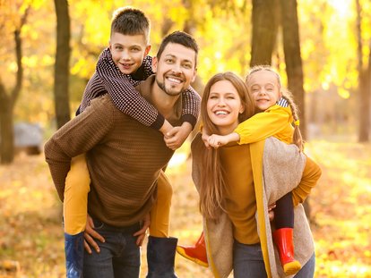 Eltern, Sohn und Tochter im herbstlichen Wald