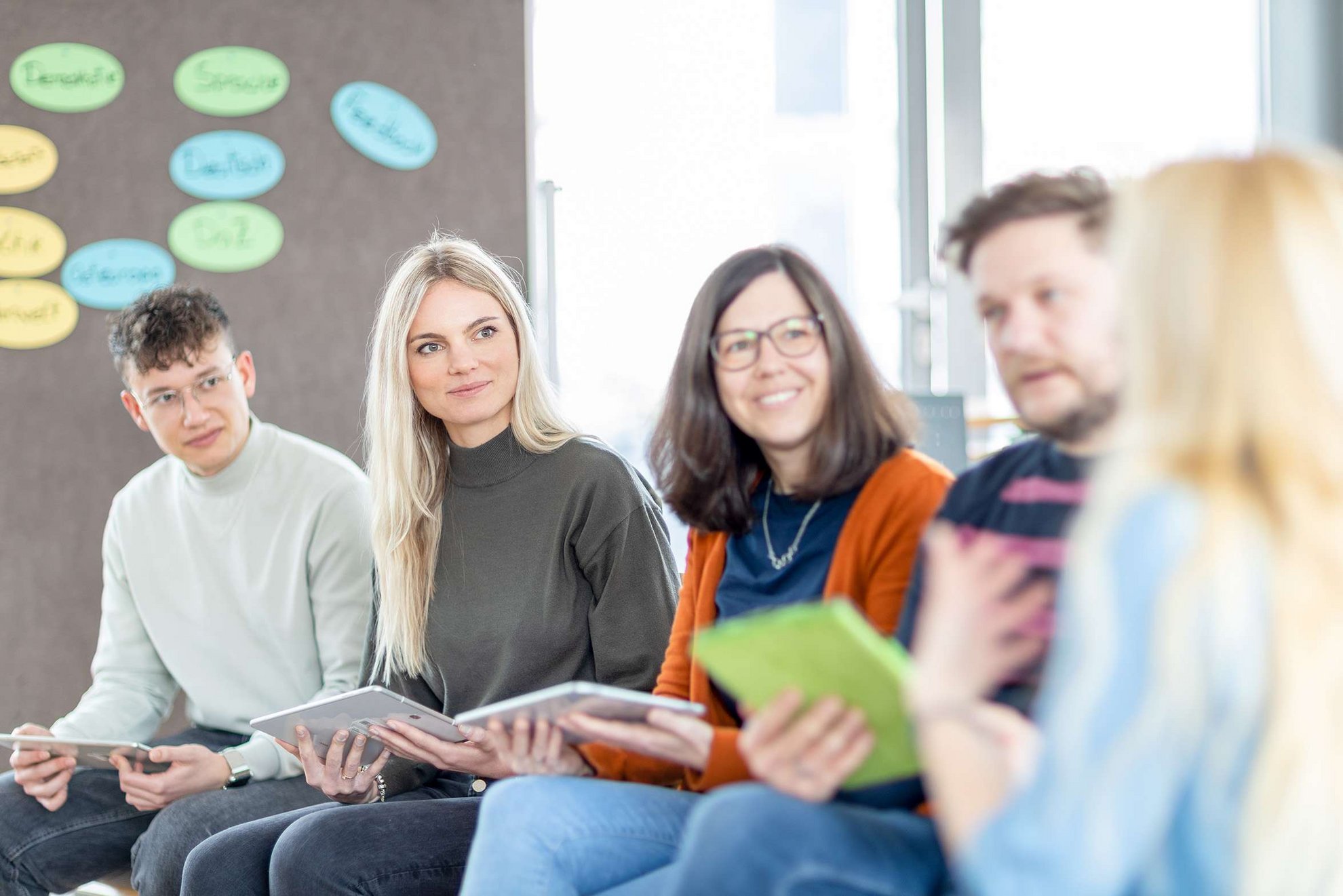 Gruppe von Erwachsenen sitzt im Stuhlkreis und spricht miteinander