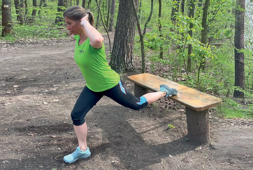 Ausfallschritt, Frau stützt sich auf Bank mit einem Bein und beugt die arme zum Kopf