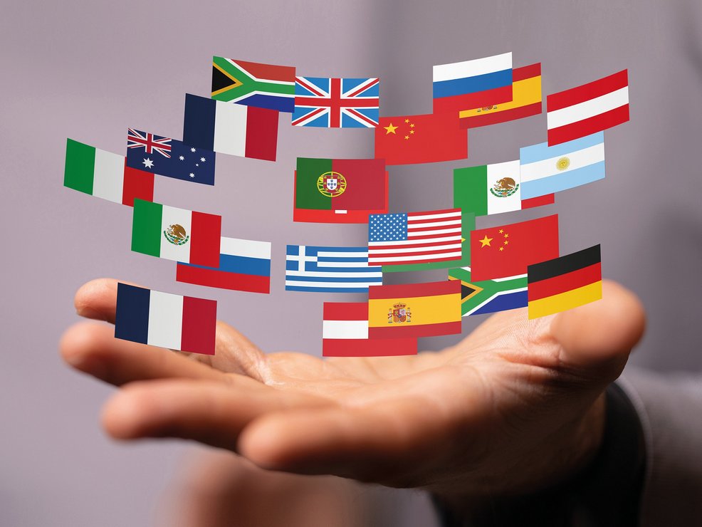 Viele verschiedene Flaggen kreißen über einer Hand