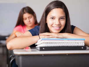 Mädchen stützt sich auf der Schulbank ab